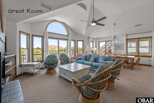 carpeted living area with visible vents, baseboards, high vaulted ceiling, and ceiling fan with notable chandelier