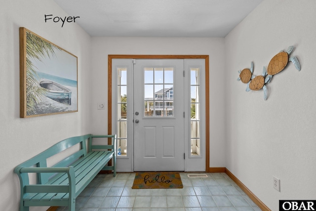 foyer with light tile patterned floors and baseboards