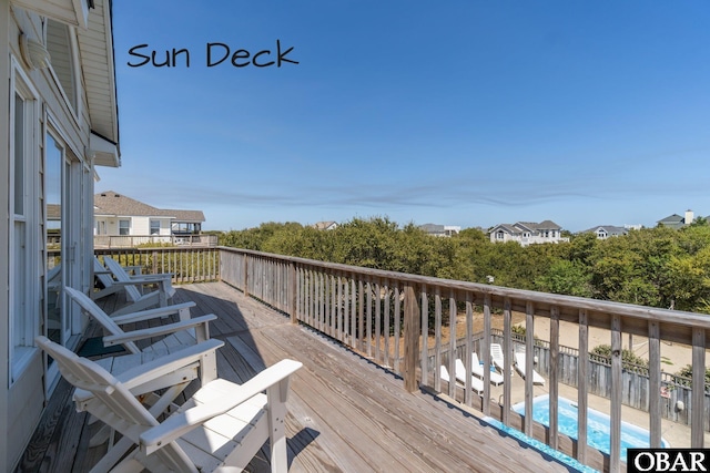 wooden deck with a fenced in pool