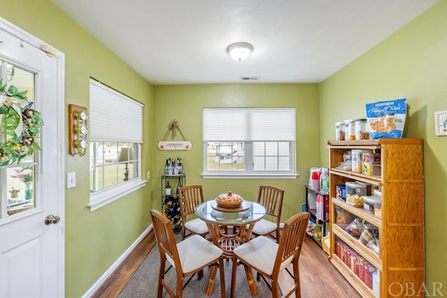 dining space featuring wood finished floors, visible vents, and baseboards