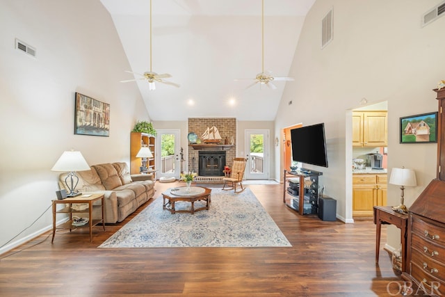 living room with dark wood-style floors, a brick fireplace, and visible vents