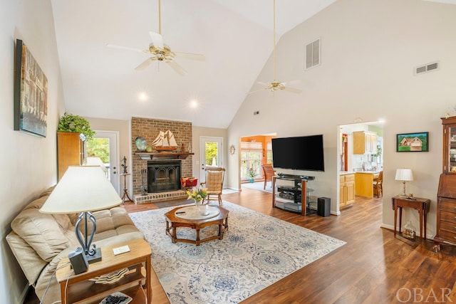 living area featuring ceiling fan, a fireplace, dark wood finished floors, and visible vents