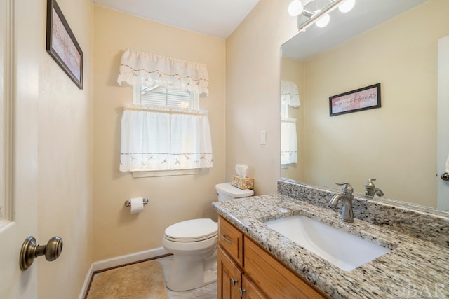 bathroom featuring vanity, toilet, and baseboards