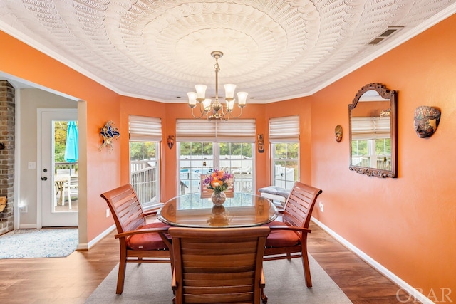 dining space featuring a wealth of natural light, a notable chandelier, and wood finished floors