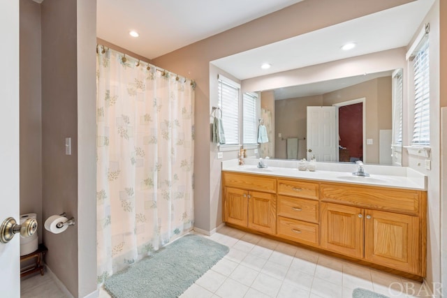 full bath with double vanity, a sink, and tile patterned floors