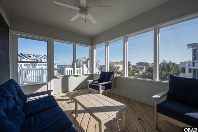 sunroom / solarium with ceiling fan and a residential view