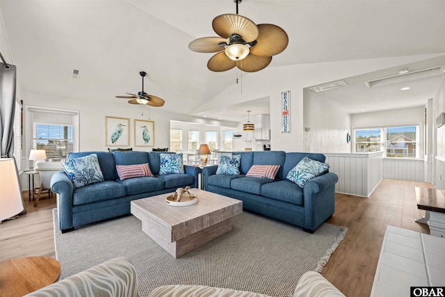 living room with lofted ceiling, ceiling fan, visible vents, and wood finished floors