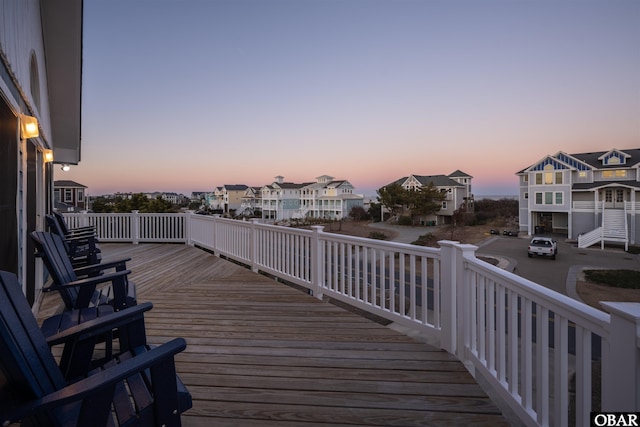 deck at dusk featuring a residential view