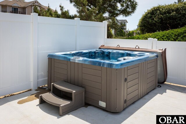 view of patio / terrace featuring a hot tub and fence