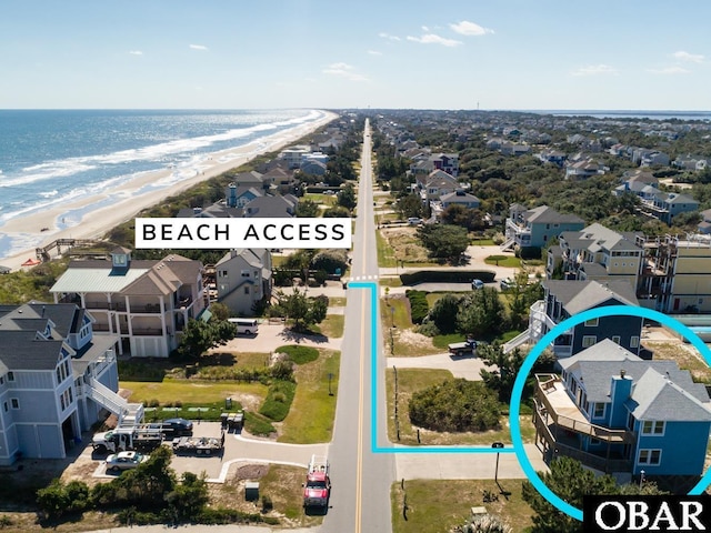 aerial view with a view of the beach, a water view, and a residential view