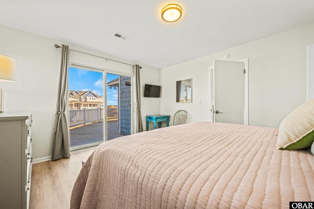 bedroom with access to outside, visible vents, light wood-style flooring, and baseboards