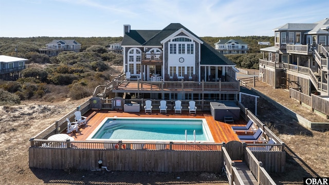 back of property featuring fence, a fenced in pool, and a patio