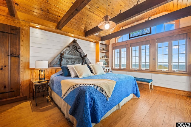 bedroom with light wood-type flooring, wooden ceiling, and wooden walls