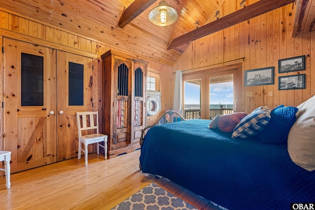 bedroom featuring vaulted ceiling with beams, wooden ceiling, light wood-style flooring, wood walls, and access to exterior