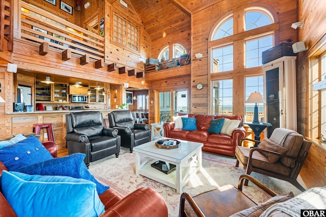 living area featuring high vaulted ceiling and wooden walls