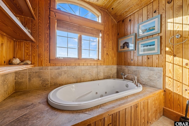 bathroom with lofted ceiling, a jetted tub, wooden ceiling, and a wealth of natural light