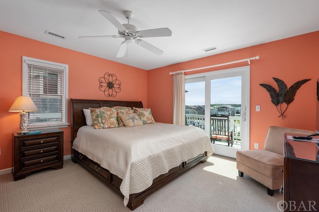 bedroom with light carpet, baseboards, visible vents, and access to exterior