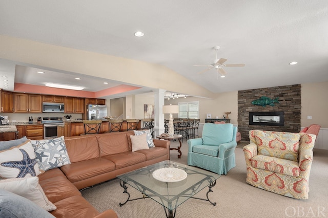 living room featuring light colored carpet, lofted ceiling, ceiling fan, ornate columns, and a fireplace