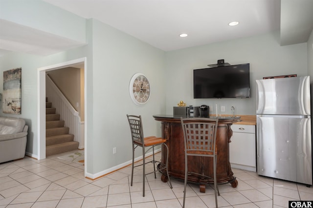 interior space featuring light tile patterned floors, recessed lighting, baseboards, light countertops, and freestanding refrigerator