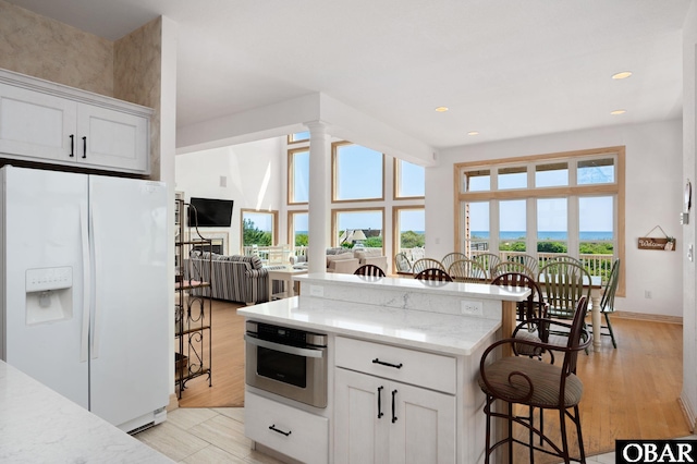 385 Deep Neck Rd Lot # 131, Corolla, NC 27927 - kitchen featuring white refrigerator with ice dispenser, oven, a breakfast bar area, healthy amount of natural light, and recessed lighting