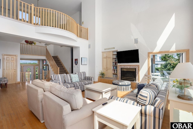 385 Deep Neck Rd Lot # 131, Corolla, NC 27927 - living area with a towering ceiling, a glass covered fireplace, light wood-type flooring, and stairs