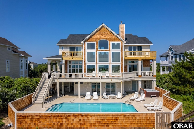 385 Deep Neck Rd Lot # 131, Corolla, NC 27927 - rear view of house featuring stairway, a balcony, a chimney, a patio area, and an outdoor pool