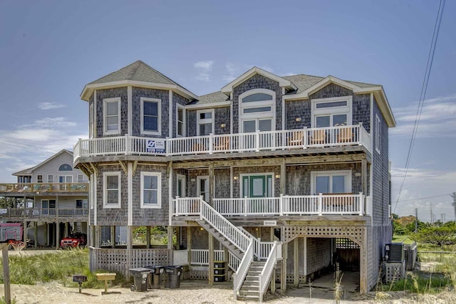 exterior space featuring a porch, roof with shingles, and stairway