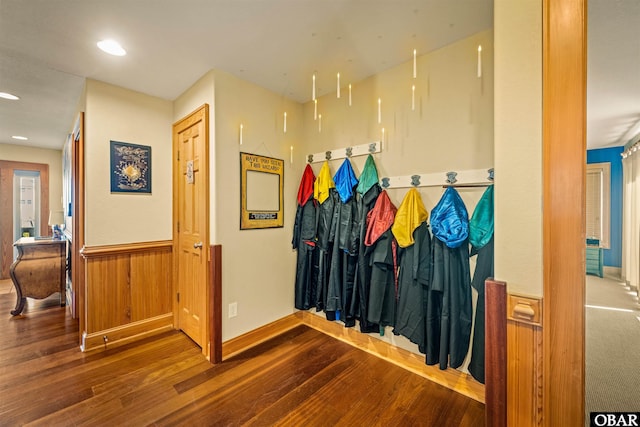 hallway with recessed lighting, wood finished floors, and a wainscoted wall