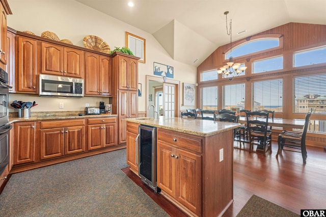 kitchen with wine cooler, dark wood-style floors, stainless steel microwave, a chandelier, and brown cabinetry