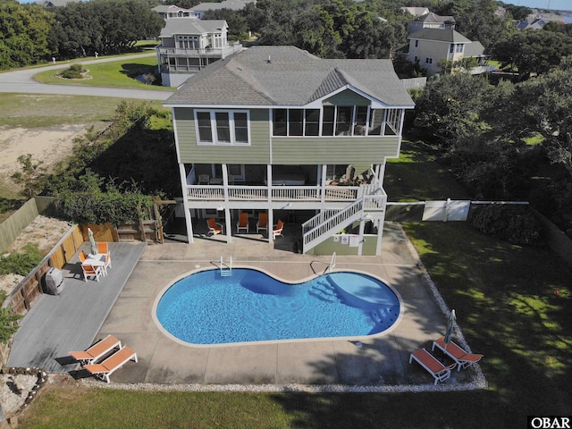 back of property with a fenced backyard, a yard, a sunroom, stairs, and a patio area