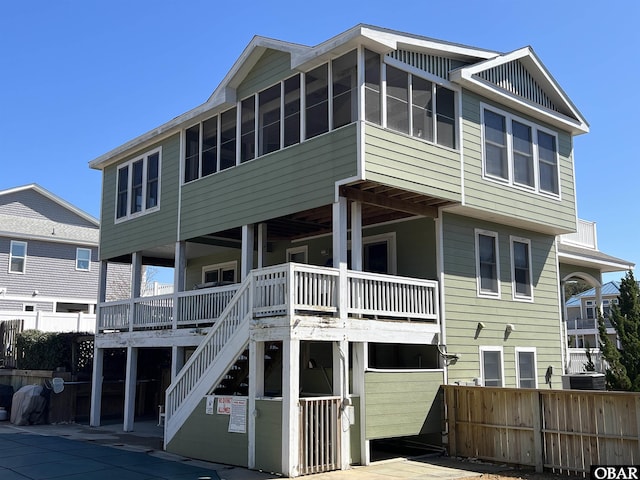 back of house featuring stairway and fence