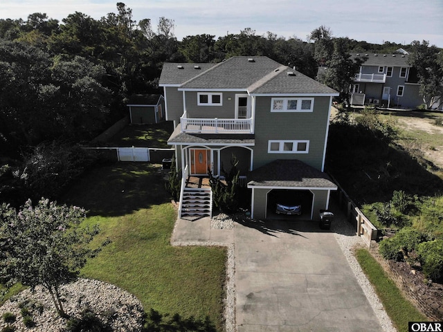 view of front of house featuring fence, stairs, a front yard, a balcony, and driveway