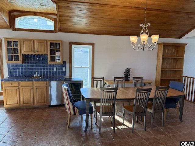 dining area with a chandelier, dark tile patterned floors, wooden ceiling, and lofted ceiling