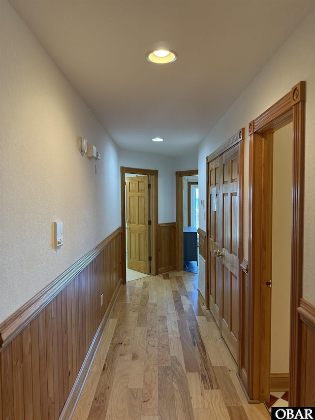 corridor with recessed lighting, wainscoting, and light wood finished floors