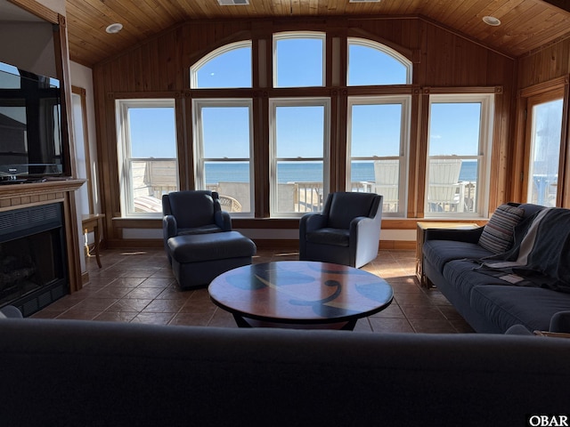 living area featuring wood ceiling, a water view, vaulted ceiling, and a fireplace