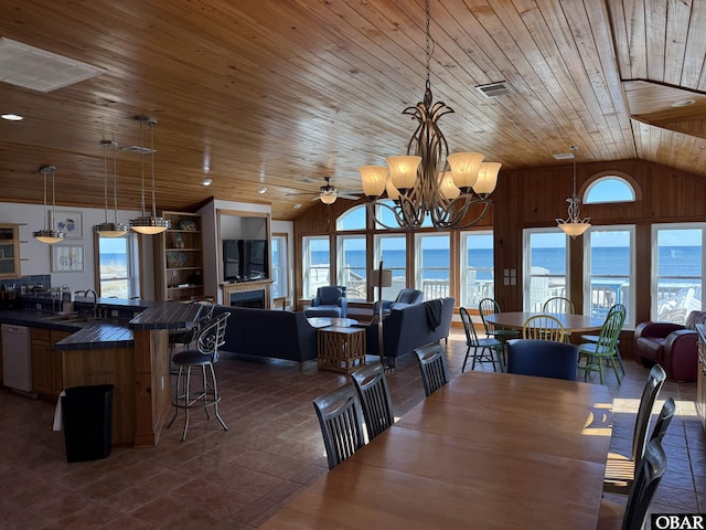 dining area with a fireplace, visible vents, vaulted ceiling, wooden ceiling, and ceiling fan with notable chandelier