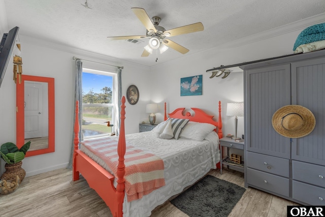 bedroom with wood finished floors, a textured ceiling, and ornamental molding