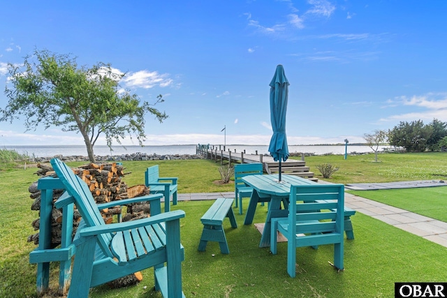 view of property's community featuring a lawn and a water view