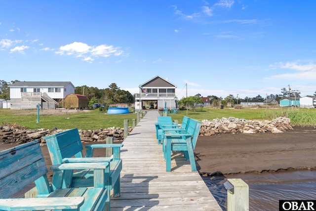 view of dock with a lawn