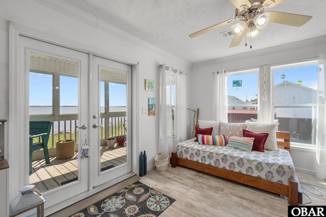 bedroom with a textured ceiling, access to exterior, crown molding, and french doors