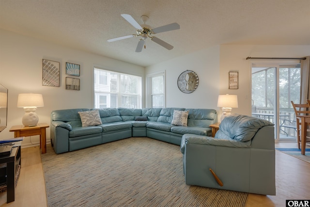 living area with ceiling fan and a textured ceiling