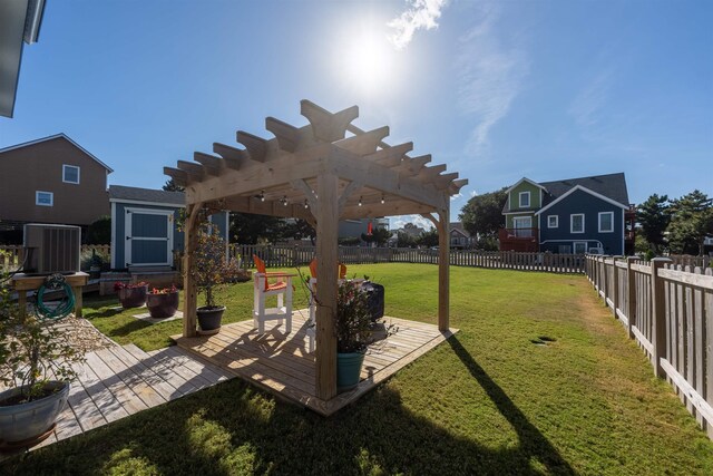 view of yard with a fenced backyard, a pergola, and an outbuilding