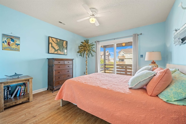 bedroom featuring access to exterior, visible vents, a ceiling fan, a textured ceiling, and wood finished floors