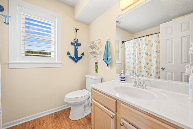 full bathroom with toilet, wood finished floors, vanity, visible vents, and baseboards