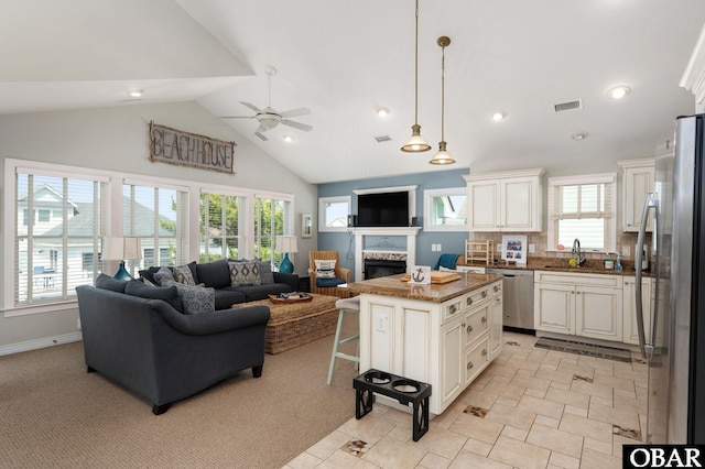 747 Hammock Ln Lot 55, Corolla, NC 27927 - kitchen with appliances with stainless steel finishes, open floor plan, ceiling fan, a fireplace, and high vaulted ceiling