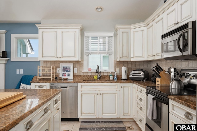 747 Hammock Ln Lot 55, Corolla, NC 27927 - kitchen with appliances with stainless steel finishes, backsplash, dark stone counters, recessed lighting, and light tile patterned floors