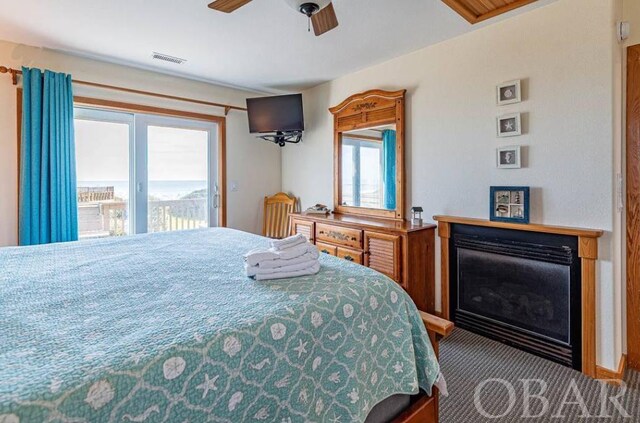 bedroom with visible vents, a ceiling fan, carpet, access to outside, and a fireplace