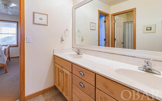 ensuite bathroom featuring connected bathroom, a ceiling fan, a sink, and double vanity