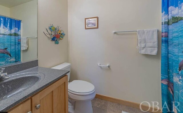 bathroom featuring baseboards, a shower with shower curtain, toilet, tile patterned flooring, and vanity