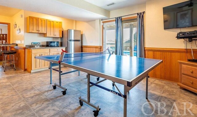 game room featuring wood walls, visible vents, and wainscoting